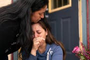 Martha Perea was comforted by a friend while clutching a photo of her husband on the steps of the house where the couple lived. Martha Perea’s husba
