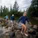 Emma Daniels, right, Abby MacFarlane and Marie Preston, back, walked across the rocks at the headwaters of the Mississippi at Lake Itasca in mid June.