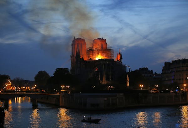 Firefighters tackle the blaze as flames and smoke rise from Notre Dame cathedral as it burns in Paris, Monday, April 15, 2019. Massive plumes of yello