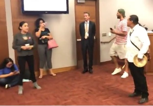 At Tuesday's Minneapolis school board meeting, some of the parents protested by walking in front of the school board members. A few parents blocked Su