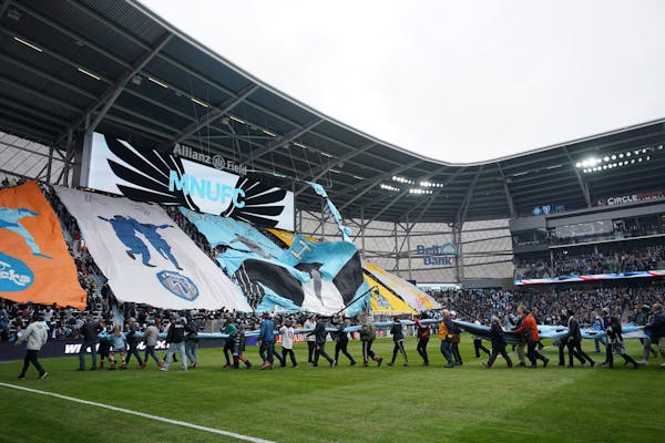 Fans carried a massive Minnesota United flag off the field as the Tifo being hoisted by fans ripped ahead of Saturday's Minnesota United home opener a