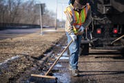 Street service worker Bradley Therres smooths asphalt over a pothole on Shepard Road in St. Paul in 2019.