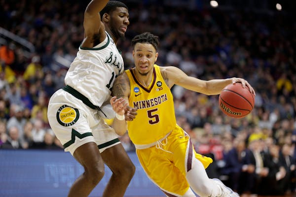 Minnesota's Amir Coffey drives past Michigan State's Aaron Henry during the first half of their NCAA tournament game.