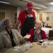 Volunteer Tom Belting visited after he served rib dinners to guests Dolores Schmeidel, left, and Mary Jo Mileski at Loaves & Fishes’ Hopkins locatio