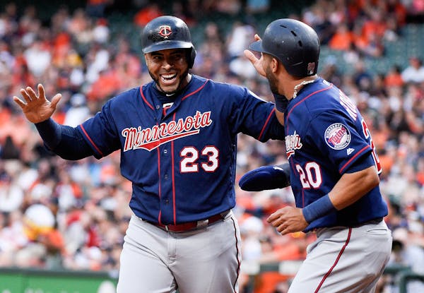 The Twins' Nelson Cruz (23) and Eddie Rosario celebrated after scoring on C.J. Cron's RBI double during the first inning against the Astros on Monday.