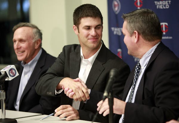 Joe Mauer shook hands with then-Twins GM Bill Smith after signing an eight-year, $184 million contract as Mauer’s agent Ron Shapiro, left, looked on