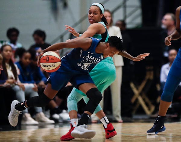 Minnesota Lynx's Danielle Robinson, front, drives past New York Liberty's Asia Durr during the first half of a WNBA basketball game Wednesday, June 12