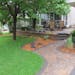 Multi-colored paver patio and walkways, and a boulder fountain with shrubs and perennials, add eye-pleasing interest and beauty to this once bare Minn
