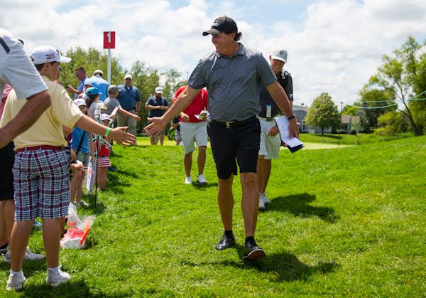 Phil Mickelson slapped hands of young fans after playing the first of a few practice holes on Tuesday at TPC Twin Cities in Blaine.