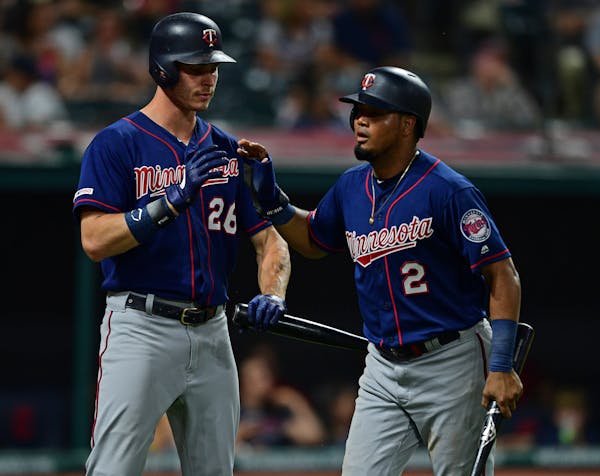 The Twins' Luis Arraez, right, is congratulated by Max Kepler after scoring a run on a two-RBI double in the eighth inning