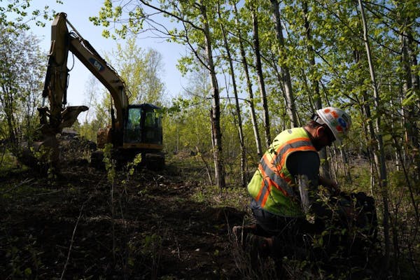In May, Eric Olson and contractor Robert Radotich, in the backhoe, did soil work at Polymet’s proposed copper-nickel mine near Hoyt Lakes, Minn.