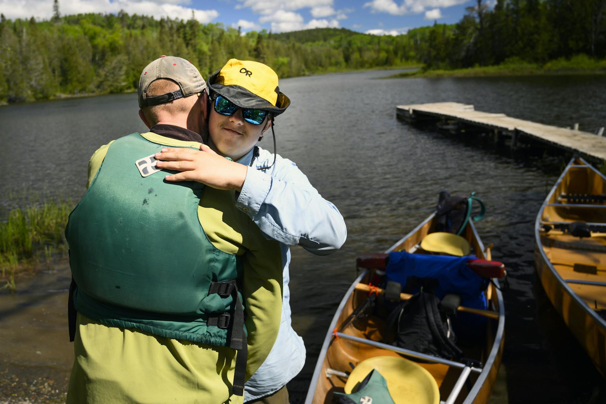 Aidan Jones and his father, Tony, hugged after completing their trek along the eastern boundary lakes June 15. They came out on Little John Lake.