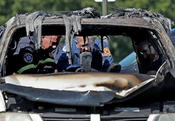 Fire investigators looked over the charred remains of a van in 2019 in a Fridley Walmart parking lot.
