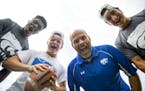 Eagan High School football seniors (left) Charles Otu, Zach Wollack, head coach Nick Johnson and senior Zack Merwin posed for a portrait on their prac
