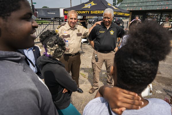 Ramsey County Sheriff Bob Fletcher, center left, and Undersheriff Bill Finney talked with teens during the substation’s grand opening Monday.