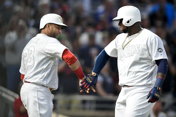 Twins third baseman Miguel Sano celebrated with designated hitter Nelson Cruz after Sano's three-run home run in the bottom of the fifth inning