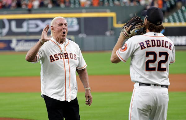 Professional wrestler legend Ric Flair, left, greets Houston Astros right fielder Josh Reddick (22) after throwing out the ceremonial first pitch befo