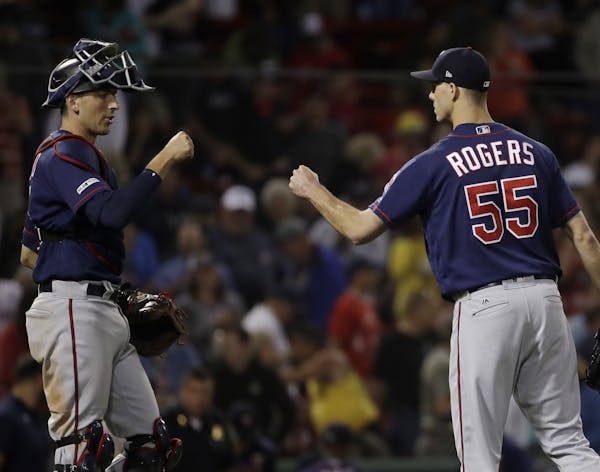 Minnesota Twins closer Taylor Rogers and catcher Jason Castro celebrate their 6-5 victory over the Boston Red Sox in a baseball game at Fenway Park, T