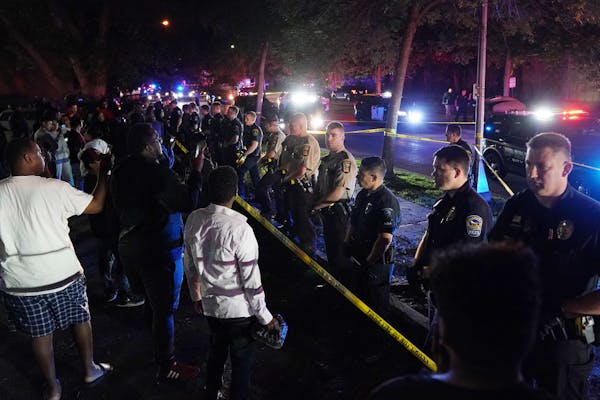 Police lined up as onlookers shouted after an officer-involved shooting Saturday night in Richfield by Edina police.