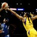 Minnesota Lynx's Odyssey Sims, center, goes up to basket while defended by Los Angeles Sparks' Candace Parker, right, and Riquna Williams during the f