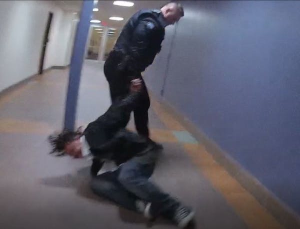 A screengrab from an officer's bodycam video shows Duluth police officer Adam Huot dragging a man by his handcuffs, which he was fired for. The Minnes