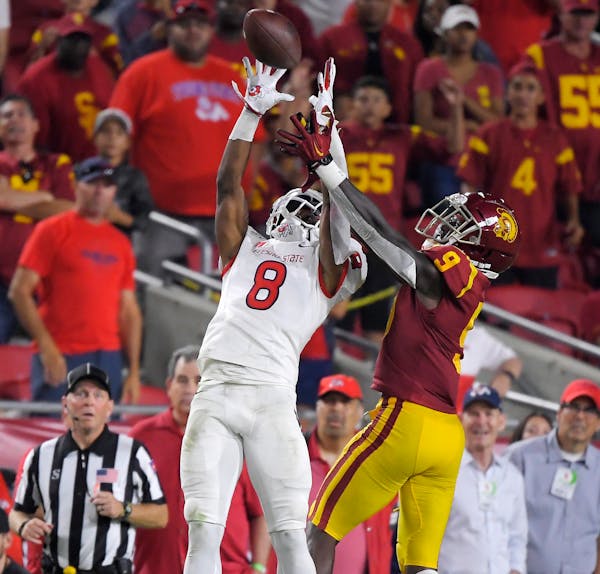 Fresno State wide receiver Chris Coleman, left, catches a pass while under pressure from Southern California cornerback Greg Johnson