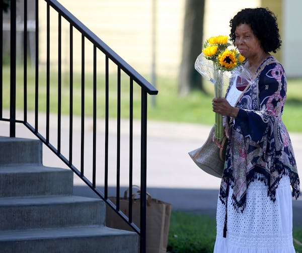 Mary Peeples, who lives near St. Albans Church of God, the scene of a fatal shooting late Wednesday, leaves flowers outside the church. Police say a S