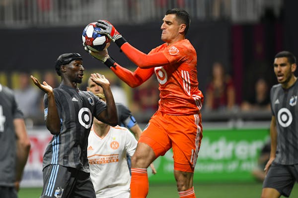 Minnesota United goalkeeper Vito Mannone (1), one of five new starters acquired during the offseason, grabs a ball in front of teammate Ike Opara, lef