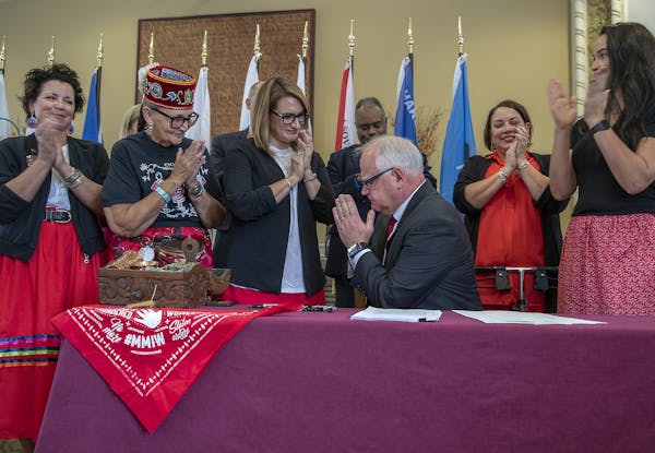 Gov. Tim Walz gestured a sign of respect to Ojibwe elders and Lt. Gov. Peggy Flanagan after he signed a bill to launch the first official meeting of t