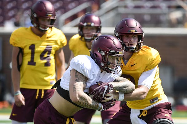 Gophers running back Shannon Brook took a handoff from quarterback Tanner Morgan during training camp last month.