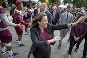 Joan Gabel, the University of Minnesota's first female president, greeted many during the "Procession to Scholars Walk, as she made her way to the ste