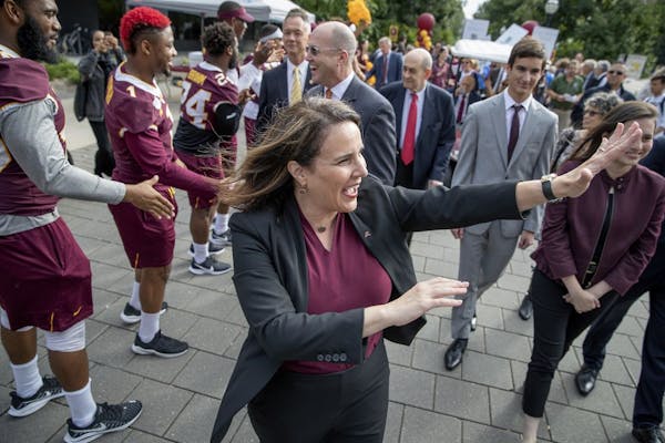 Joan Gabel, the University of Minnesota's first female president, greeted many during the "Procession to Scholars Walk, as she made her way to the ste