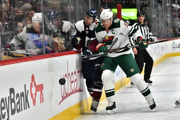 Wild center Mikko Koivu pounds Avalanche defenseman Conor Timmins into the boards during the first period