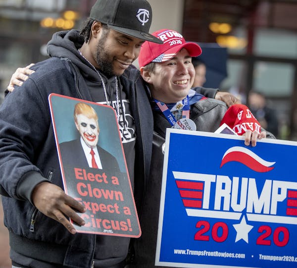 Anti-Trump Willy Jenkins, left, and Trump supporter Chris Windego, right, gave each other a hug as they waited outside the Target Center in preparatio