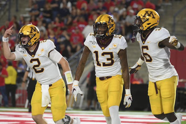 Gophers quarterback Tanner Morgan, wide receiver Rashod Bateman (13) and wide receiver Tyler Johnson (6) celebrated after a touchdown against Fresno S