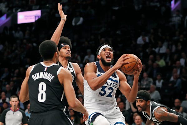 Brooklyn's Spencer Dinwiddie and Jarrett Allen, center, defend against Timberwolves center Karl-Anthony Towns during the first half.