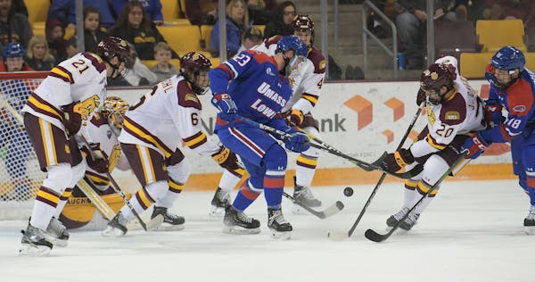 Minnesota Duluth forward Jackson Cates battles for the puck in the first period against UMass Lowell’s Zach Kaier