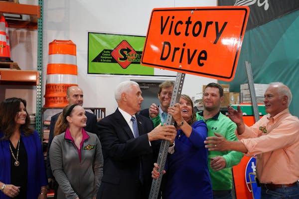 Safety Signs vice president Jay Blanchard, right, his wife, company president Sue Blanchard, and U.S. Vice President Mike Pence, laughed as they tried