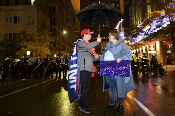 Trump supporter Chris Windego, of International Falls, and Jennifer Fairchild, of Minneapolis, had a civil conversation as Windego shared his umbrella