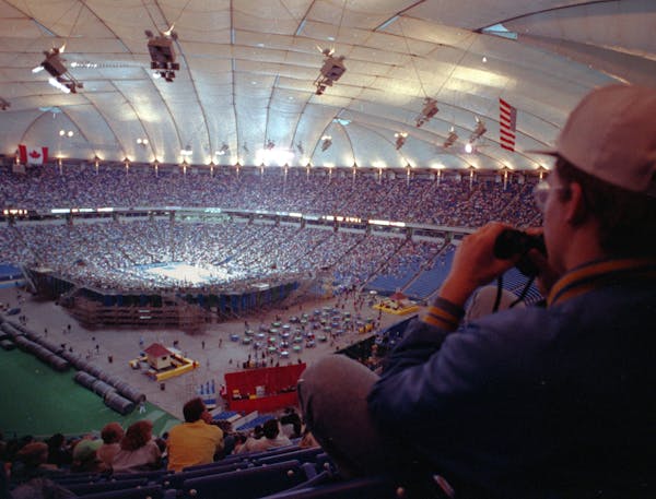 Erik Gafkjen, of Columbia Heights, uses binoculars to watch the Minnesota Timberwolves play the Denver Nuggets at the Metrodome on April 17, 1990. (Br