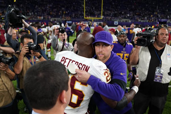 Former Minnesota Vikings star Washington Redskins running back Adrian Peterson (26) was greeted by Minnesota Vikings wide receiver Adam Thielen (19) a
