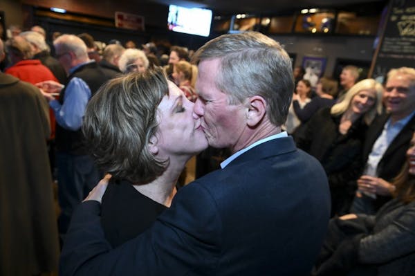 Tim Busse and his wife, Heather, shared a celebratory kiss Tuesday night in Bloomington after Tim Busse was elected mayor.