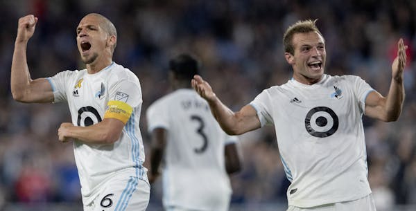 Minnesota United's Osvaldo Alonso (left) celebrates with teammate Chase Gasper (right) after Alonso scored a goal against Sporting Kansas City during 