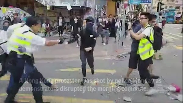 Hong Kong police shoot protester in the street