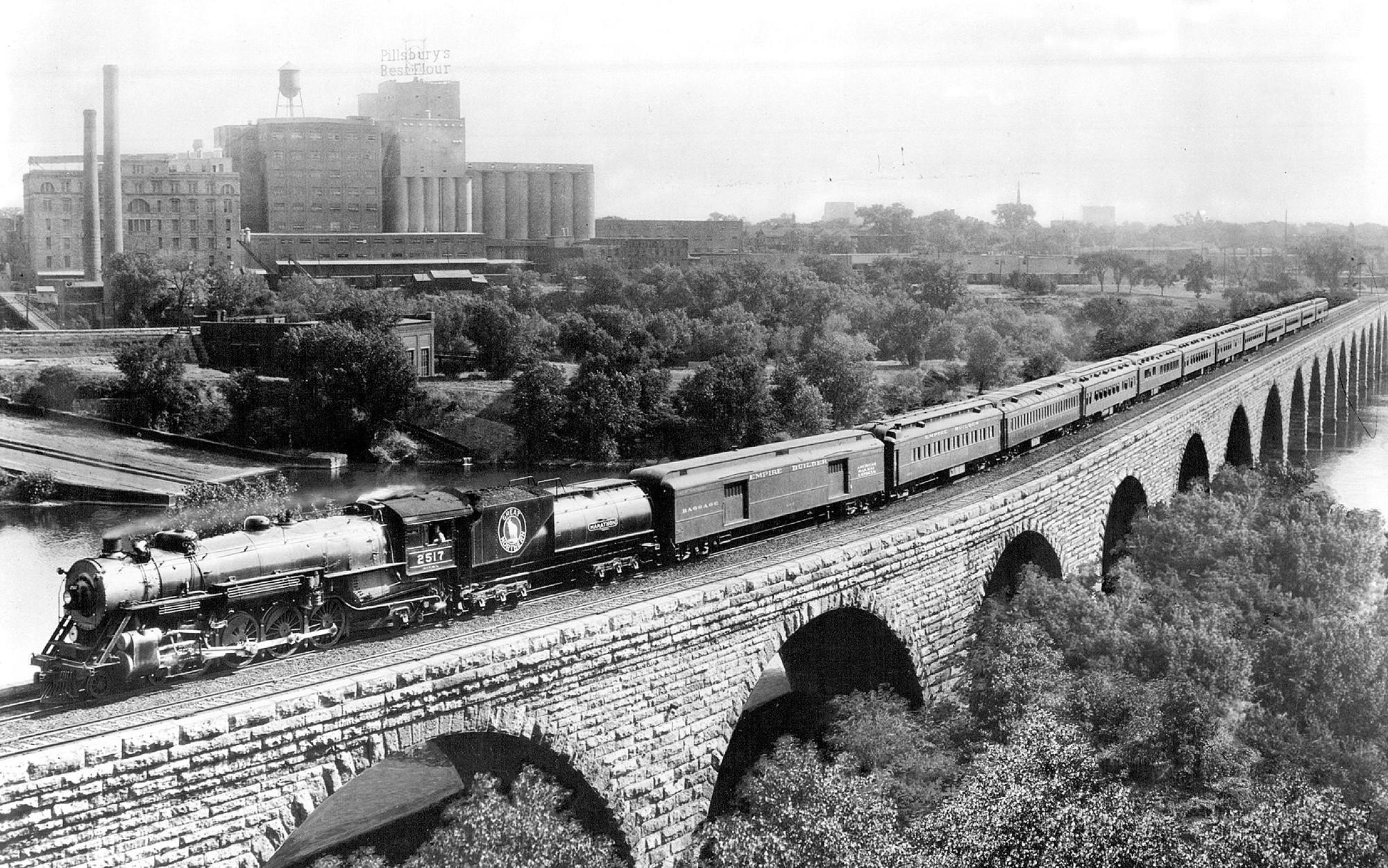 Great Northern Railway's first Empire Builder is pictured on the Stone Arch Bridge crossing the Mississippi River, likely in the 1920s or 1930s. 