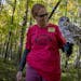 Anne Cammack holds a barred owl in the woods of the nature center.