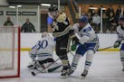Andover defenseman Wyatt Kaiser (5) fought his way past Blake's Matt Olive to score the first of his two goals in the Huskies' 6-3 victory. Photo by M