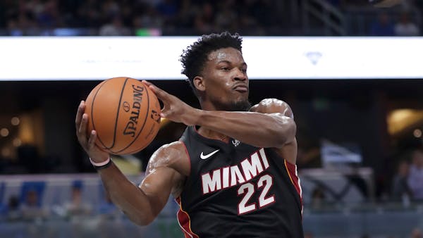 Miami Heat forward Jimmy Butler passes the ball during the first half of an NBA preseason basketball game against the Orlando Magic, Thursday, Oct. 17