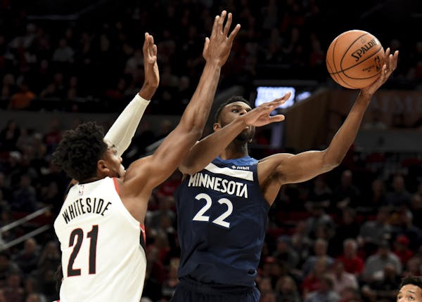 Minnesota Timberwolves forward Andrew Wiggins, right, drives to the basket on Portland Trail Blazers center Hassan Whiteside during the first quarter 