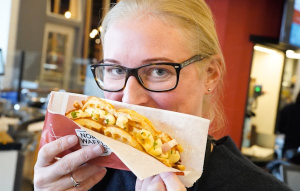 Nordic Waffles owner Stine Aasland held a Bacon, Mac & Cheese waffle at her stand which is inside Rosedale Mall’s new food hall, Potluck. ] GLEN STU